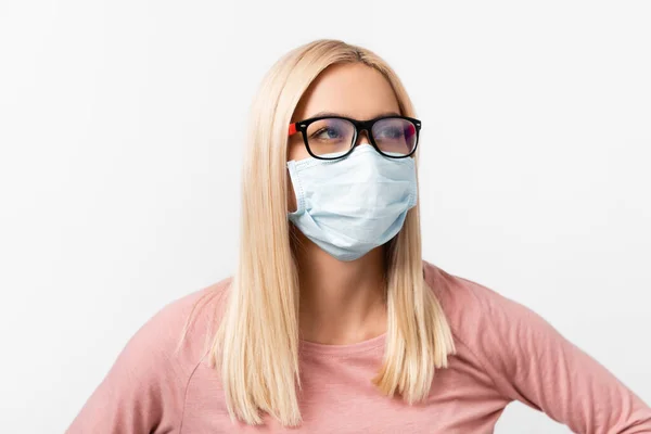 Mujer rubia en gafas y máscara médica mirando hacia otro lado aislado en gris - foto de stock