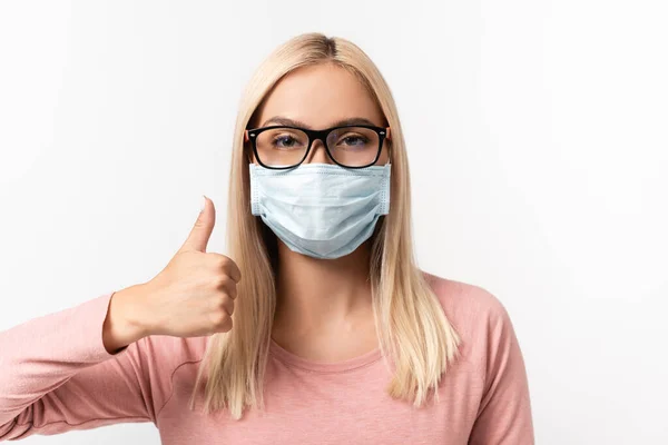 Женщина в медицинской маске и очках показывает большой палец на белом — стоковое фото