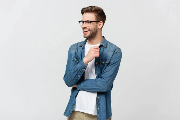 Homme joyeux en jean chemise et lunettes regardant loin isolé sur gris — Photo de stock