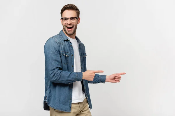 Веселий чоловік в окулярах вказує пальцями ізольовано на сірий — стокове фото