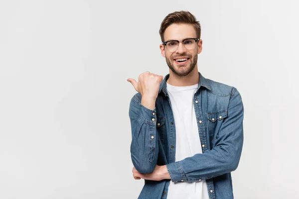 Smiling man in eyeglasses pointing with finger isolated on grey — Stock Photo