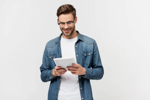 Lächelnder Mann mit Brille hält digitales Tablet isoliert auf grau — Stockfoto