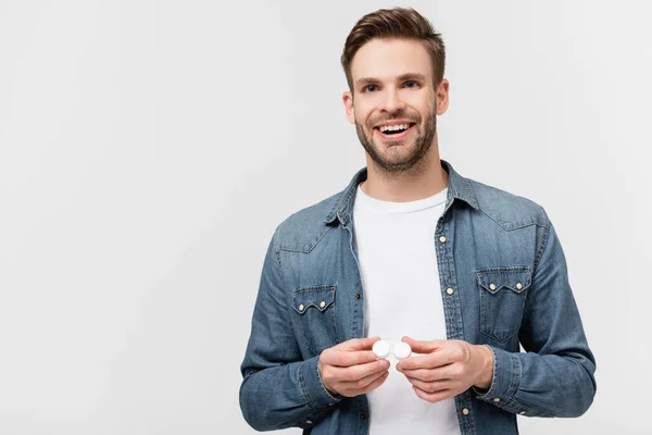 Smiling man holding case with contact lenses isolated on grey — Stock Photo