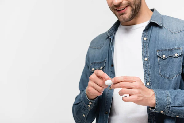 Box with contact lens in hands of smiling man on blurred background isolated on grey — Stock Photo