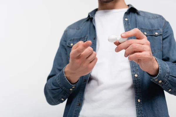 Low angle view of contact lens and container in hands of man on blurred background isolated on grey — Stock Photo