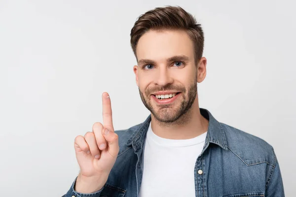 Hombre sonriente mirando a la cámara mientras sostiene la lente de contacto aislada en gris - foto de stock