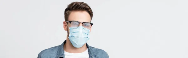 Junger Mann mit vernebelter Brille und medizinischer Maske isoliert auf grauem Banner — Stockfoto