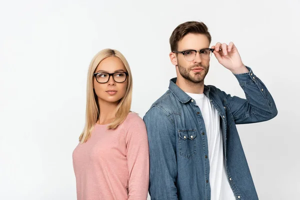 Junger Mann berührt Brille nahe blonder Freundin isoliert auf grau — Stockfoto