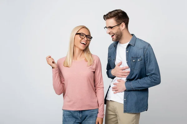 Junge Frau mit Brille steht neben fröhlichem Freund isoliert auf grau — Stockfoto