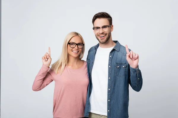 Lächelndes Paar in Brille zeigt mit Fingern auf Grau — Stockfoto