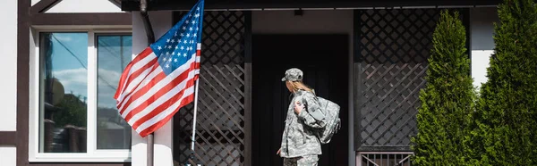Military servicewoman with backpack leaving house, standing on threshold, banner — Stock Photo