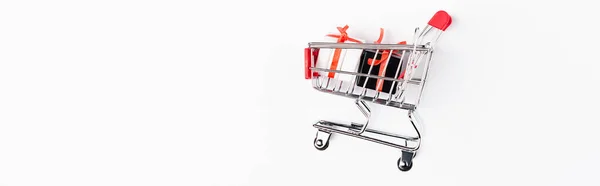 Horizontal image of toy gift boxes and shopping cart on white background — Stock Photo