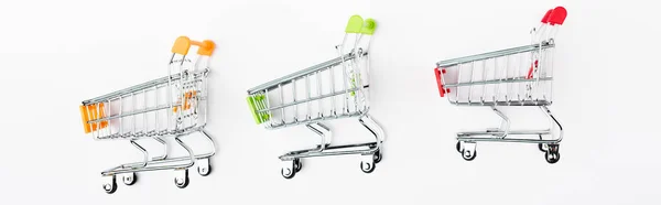 Panoramic orientation of toy shopping carts on white background — Stock Photo