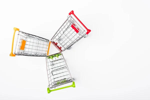 Top view of colorful toy shopping carts on white background — Stock Photo