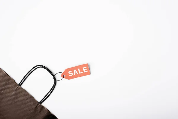 Vista dall'alto del cartellino del prezzo con scritte in vendita su shopping bag nero su sfondo bianco — Foto stock