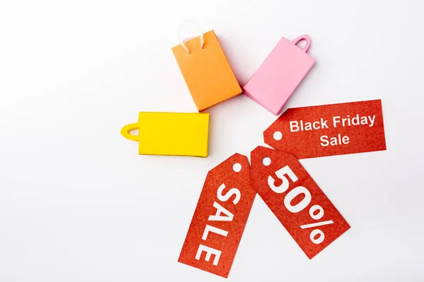 Top view of toy shopping bags and price tags with black friday sale on white background — Stock Photo