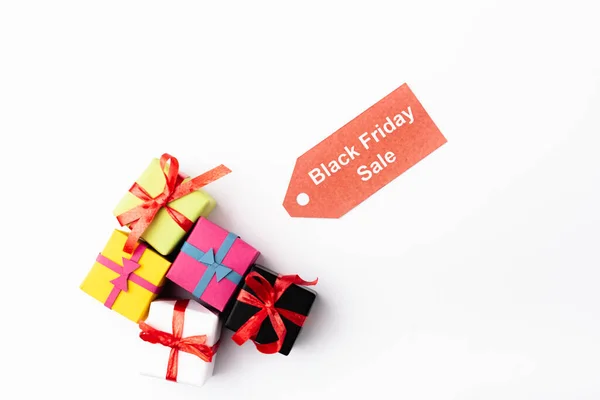 Top view of toy gifts and price tag with black friday sale lettering on white background — Stock Photo