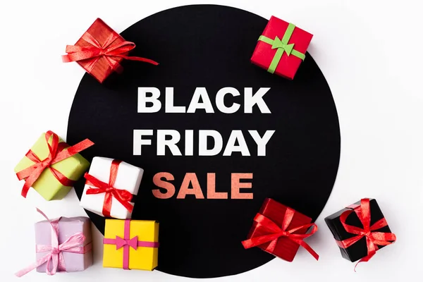Vue du dessus des cadeaux de jouets près de cercle noir avec noir vendredi vente lettrage sur fond blanc — Photo de stock