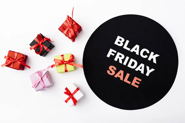 Top view of colorful toy gifts near circle with black friday lettering on white background — Stock Photo