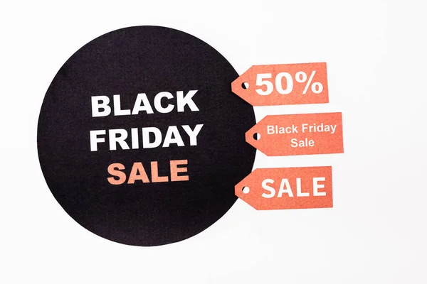 Top view of red price tags near black circle with black friday lettering on white background — Stock Photo