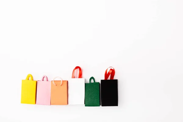 Vista superior de bolsas de compras de colores sobre fondo blanco - foto de stock