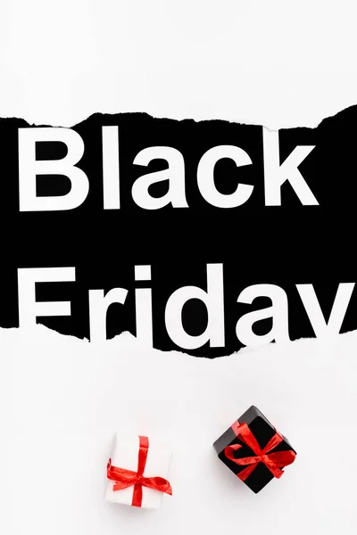 Vue du dessus du lettrage noir du vendredi près de petits cadeaux sur fond blanc — Photo de stock