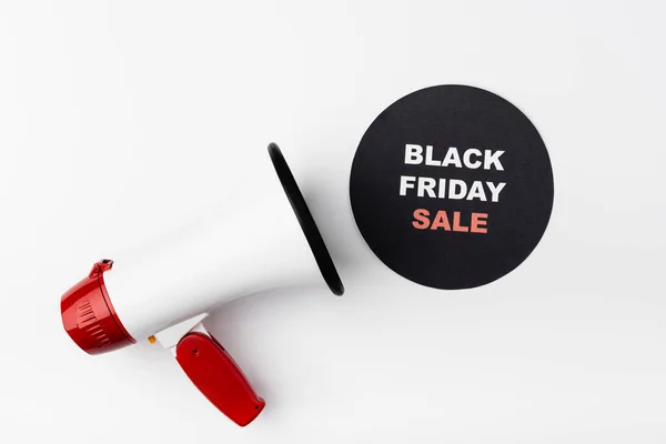 Top view of loudspeaker and black circle with black friday sale lettering on white background — Stock Photo