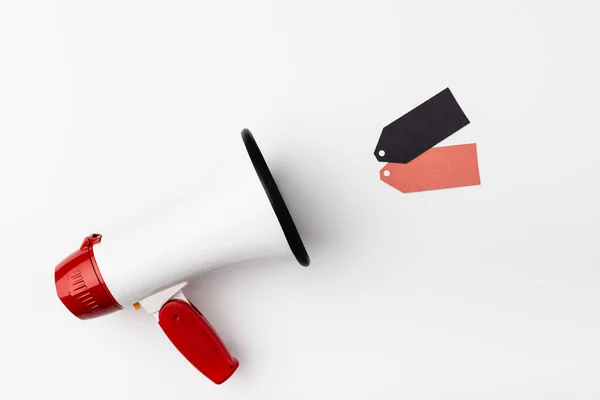 Top view of loudspeaker near empty price tags on white background — Stock Photo