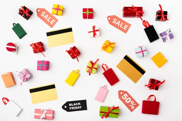 Vista superior de cartões de crédito com etiquetas de preço e sacos de compras de brinquedo no fundo branco — Fotografia de Stock