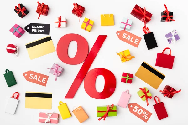 Top view of percent sign with credit cards and toy shopping bags on white background — Stock Photo