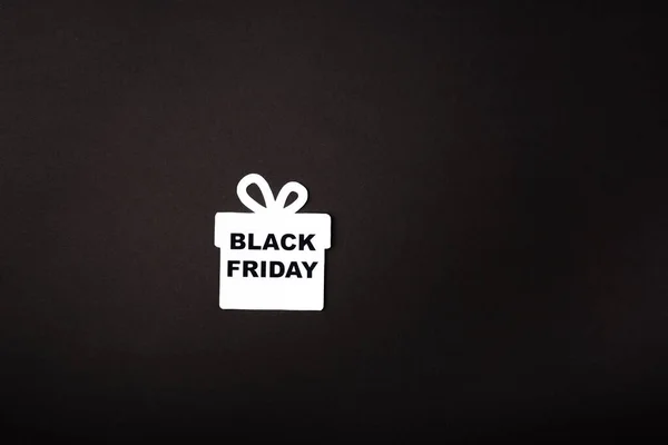 Vue du dessus de la boîte cadeau en papier avec lettrage noir vendredi sur fond noir — Photo de stock