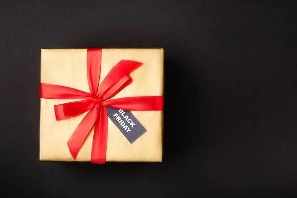 Vista dall'alto della confezione regalo con cartellino del prezzo con venerdì nero su sfondo nero — Foto stock