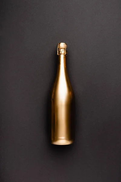 Vue du dessus d'une bouteille de champagne dorée sur fond noir — Photo de stock
