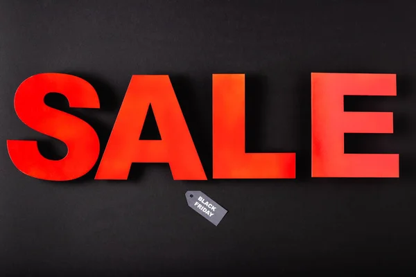 Top view of sale lettering near price tag with black friday words on black background — Stock Photo
