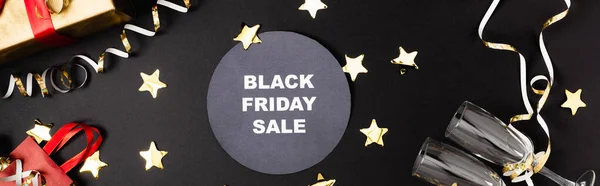 Website header of round with black friday sale lettering near gift, glasses and golden decor on black background — Stock Photo