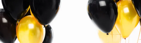 Panoramic shot of black and yellow balloons isolated on white — Stock Photo