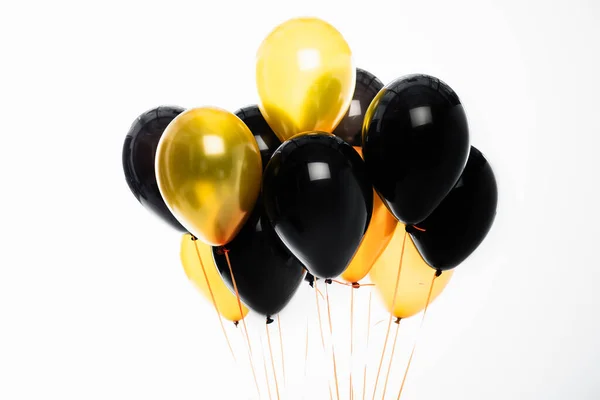 Festliche schwarze und goldene Luftballons auf weißem Grund — Stockfoto