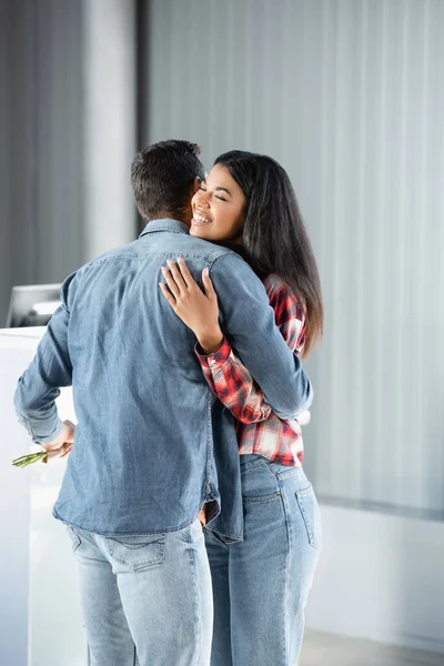 Uomo incontro e abbracciare felice africano americano fidanzata in aeroporto — Foto stock