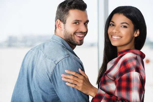 Felice coppia multiculturale sorridente in aeroporto — Foto stock