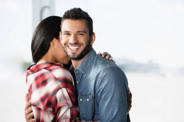 Afroamerikanerin umarmt fröhlichen Freund am Flughafen — Stockfoto