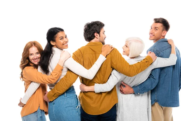 Personas multiétnicas sonriendo a la cámara mientras abrazan aislados en blanco - foto de stock