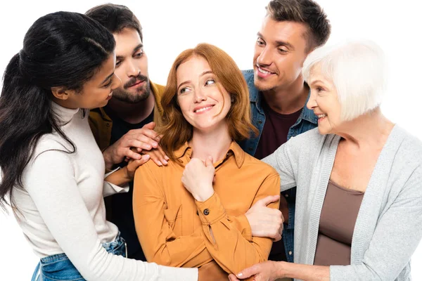 Sorrindo multiétnico pessoas abraçando mulher isolada no branco — Fotografia de Stock