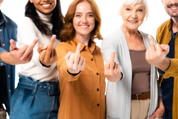 Smiling multicultural people showing middle fingers on blurred background isolated on white — Stock Photo