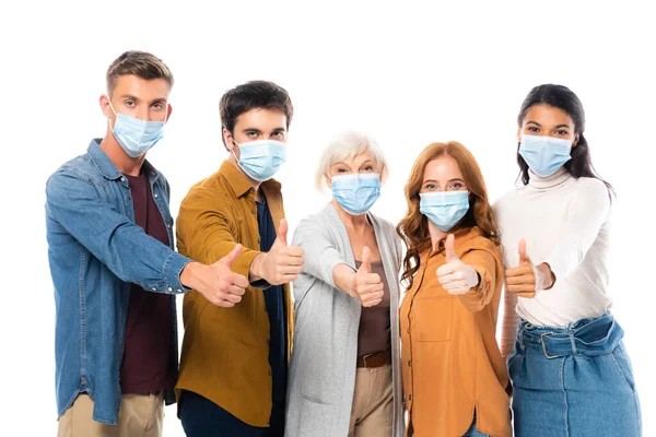 Amigos multiculturais mostrando como ao usar máscaras médicas isoladas em branco — Fotografia de Stock