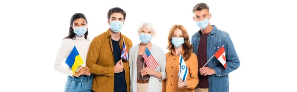 Personnes multiethniques dans des masques médicaux tenant des drapeaux isolés sur blanc, bannière — Photo de stock