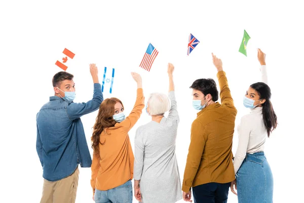 Personas multiétnicas con máscaras médicas con banderas de países aislados en blanco - foto de stock