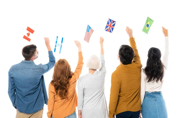 Вид ззаду на багатоетнічних людей, що тримають прапори графств ізольовані на білому — стокове фото