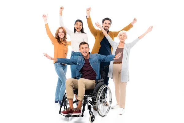 Cheerful multiethnic friends standing near man in wheelchair on white background — Stock Photo