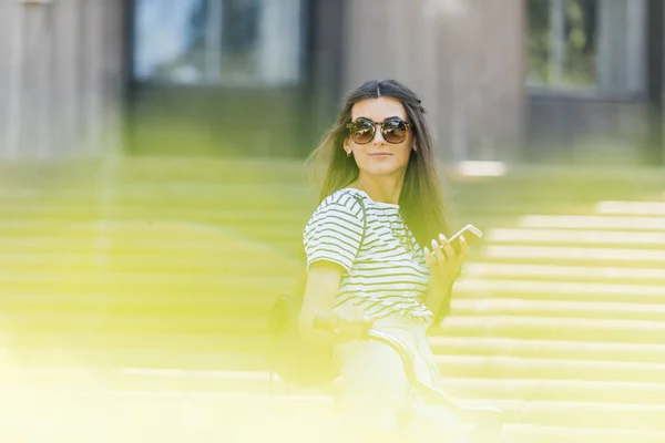 Vista Lateral Jovem Mulher Sorridente Óculos Sol Com Smartphone Rua — Fotografia de Stock