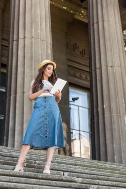 Genç güzel kadın Caddesi üzerinde adımlar üzerinde duran dijital tablet kullanma
